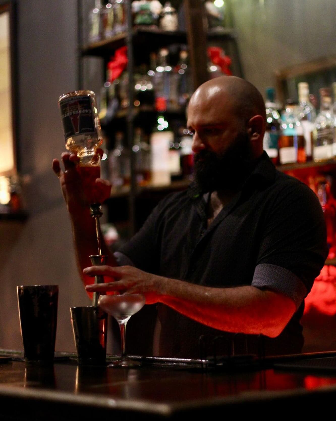 Iván Avilés pouring a cocktail behind a bar in Puerto Rico
